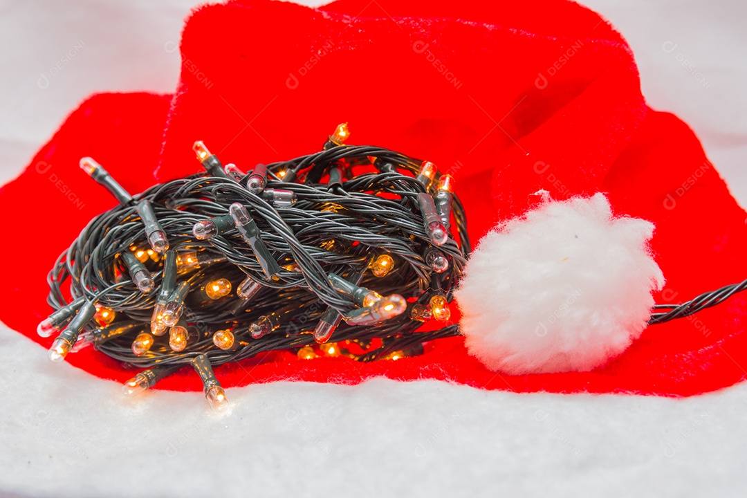 Luzes decorativas de Natal com um chapéu vermelho sobre fundo branco no Rio de Janeiro.