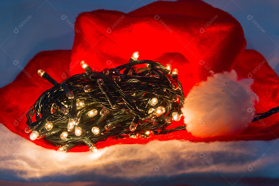 Luzes decorativas de Natal com um chapéu vermelho sobre fundo branco no Rio de Janeiro.