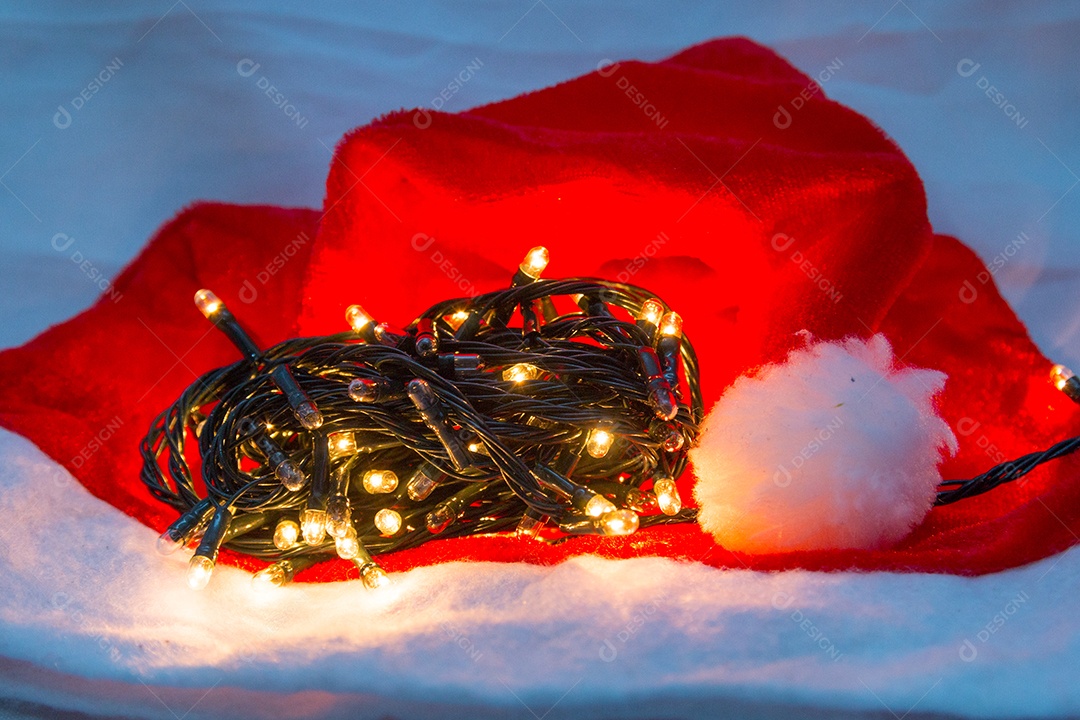 Luzes decorativas de Natal com um chapéu vermelho sobre fundo branco no Rio de Janeiro.