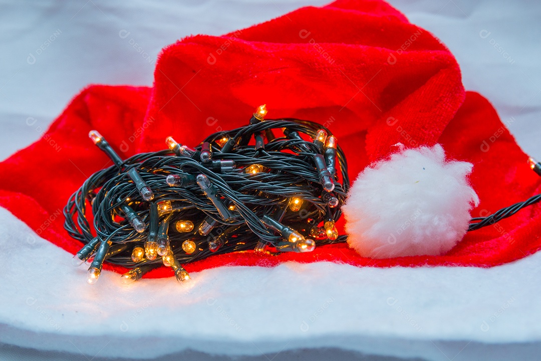 Luzes decorativas de Natal com um chapéu vermelho sobre fundo branco no Rio de Janeiro.