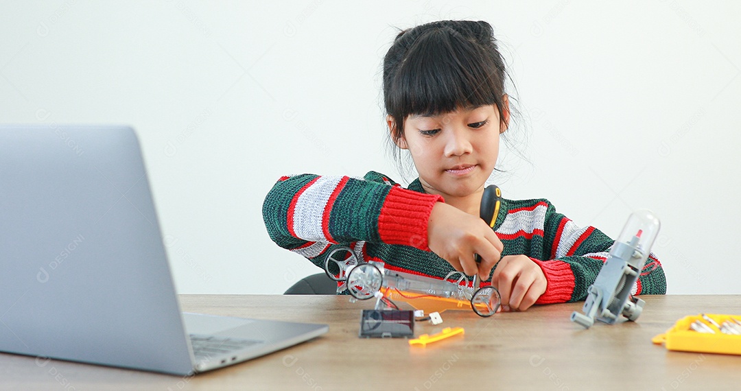 A garotinha asiática construindo carro robótico na aula de ciências