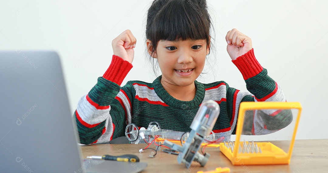 A garotinha asiática construindo carro robótico na aula de ciências
