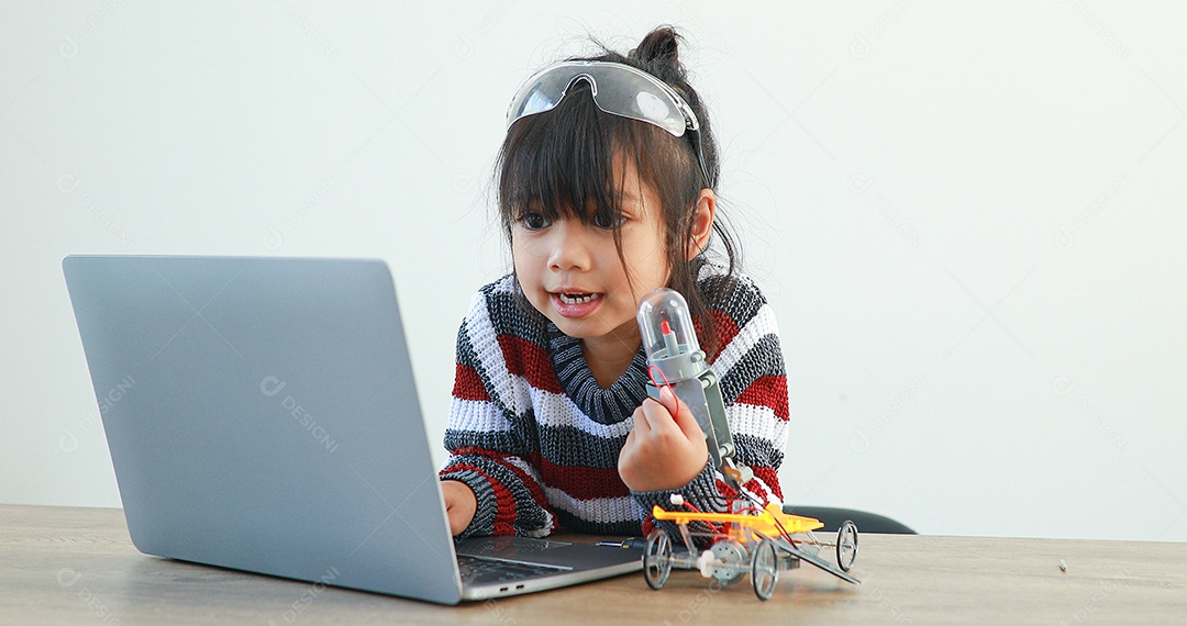 A garotinha asiática construindo carro robótico na aula de ciências
