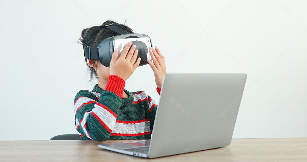 Linda menina criança usando oculos realidade virtual usando notebook