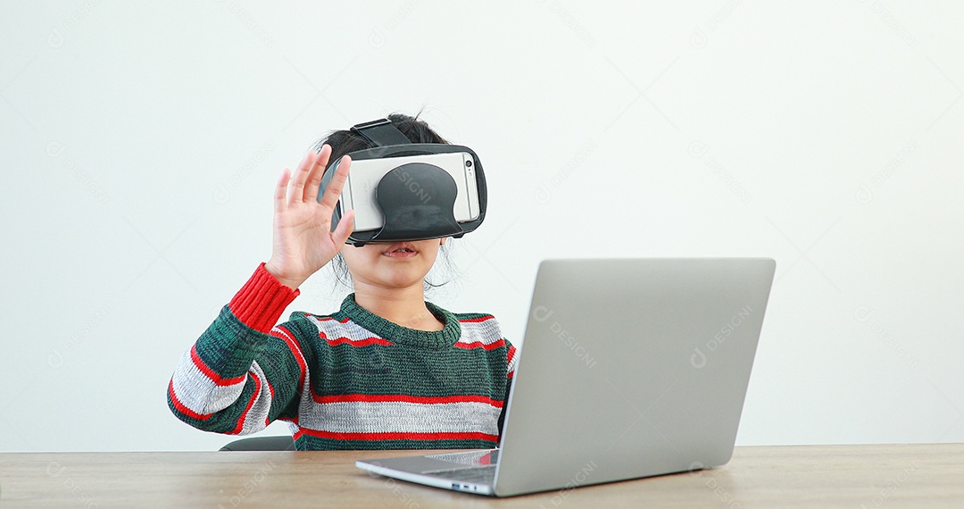 Linda menina criança usando oculos realidade virtual usando notebook