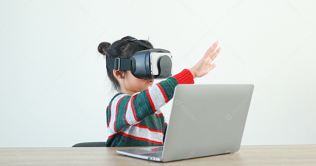 Linda menina criança usando oculos realidade virtual usando notebook