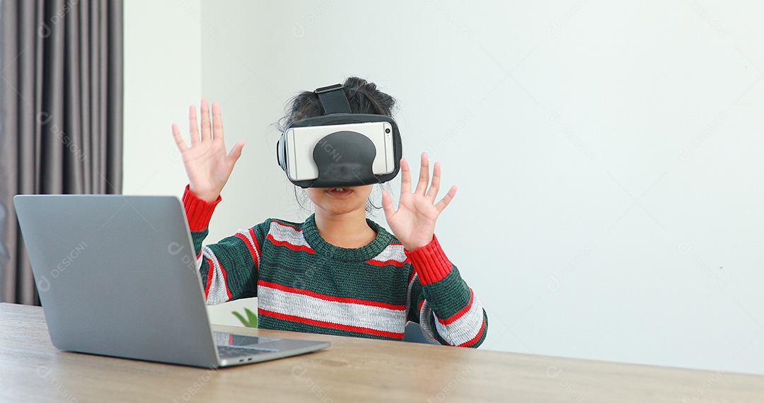 Linda menina criança usando oculos realidade virtual usando notebook