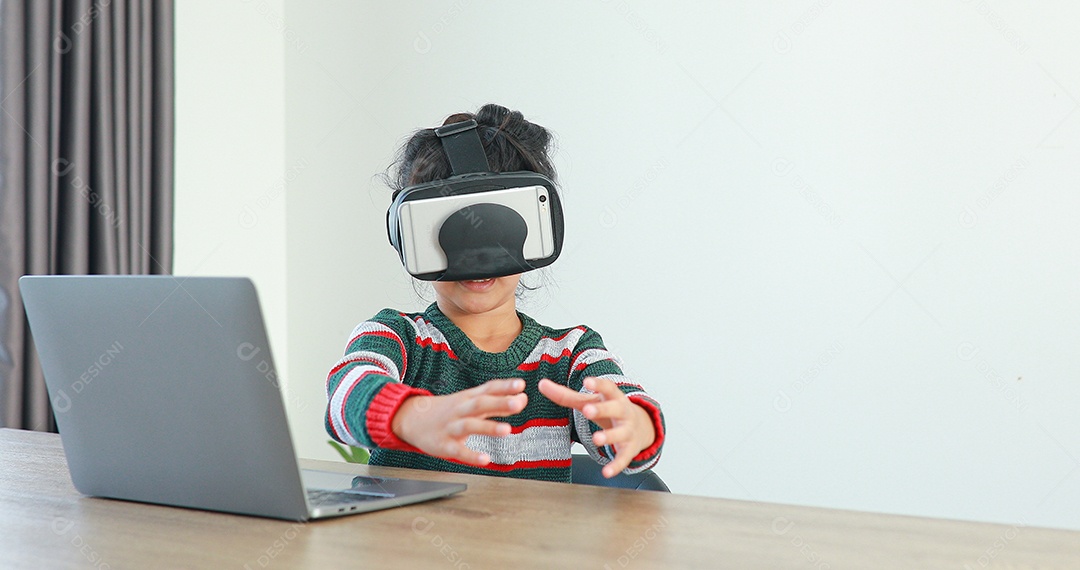 Linda menina criança usando oculos realidade virtual usando notebook