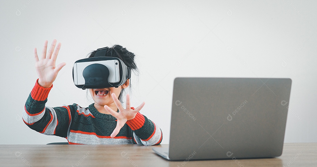 Linda menina criança usando oculos realidade virtual usando notebook