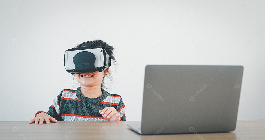 Linda menina criança usando oculos realidade virtual usando notebook