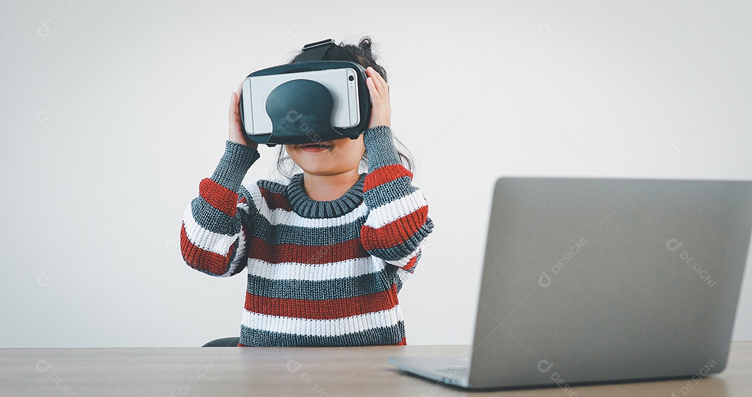 Linda menina criança usando oculos realidade virtual usando notebook