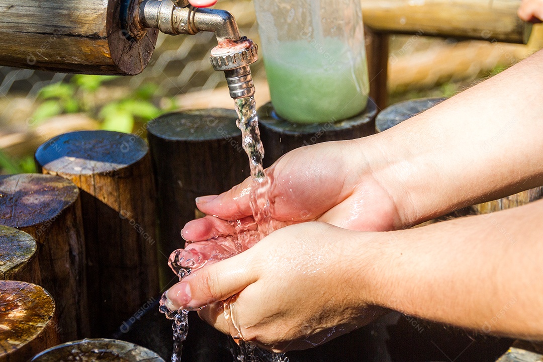 Mulher lavando as mãos ao ar livre no Rio de Janeiro Brasil.