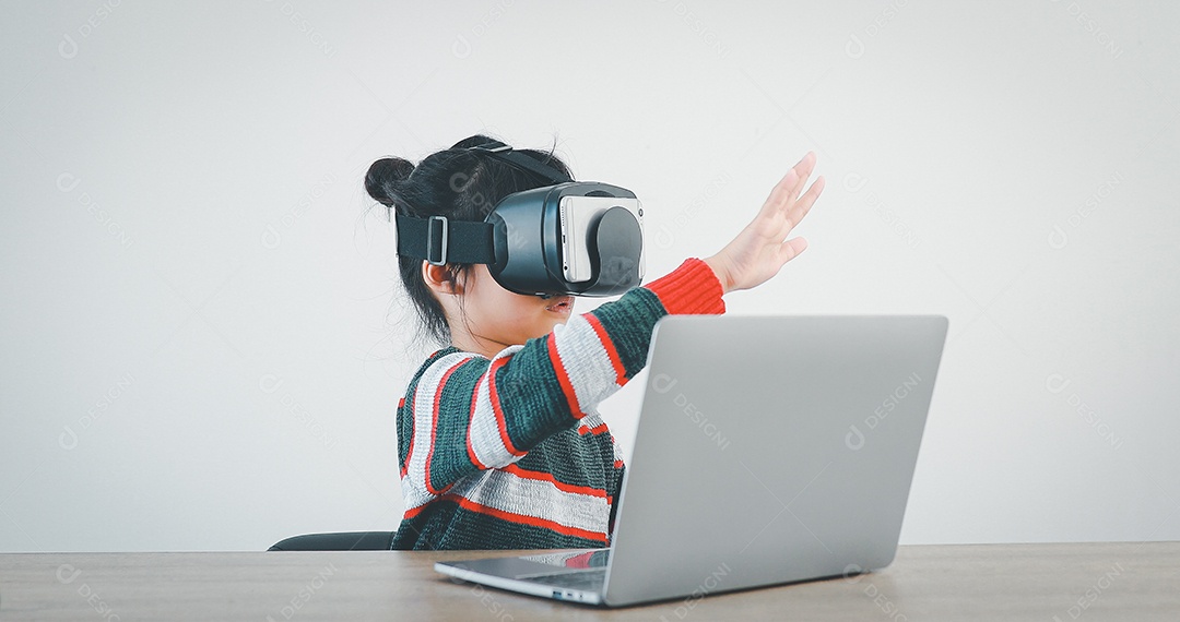 Linda menina criança usando oculos realidade virtual usando notebook
