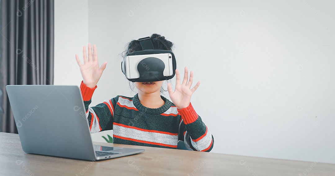 Linda menina criança usando oculos realidade virtual usando notebook