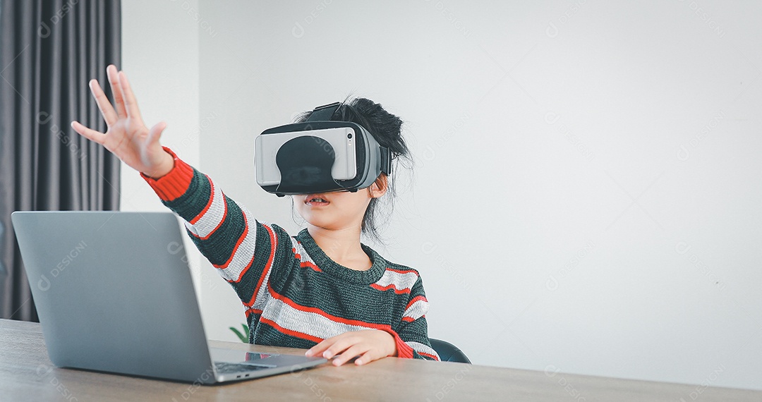 Linda menina criança usando oculos realidade virtual usando notebook