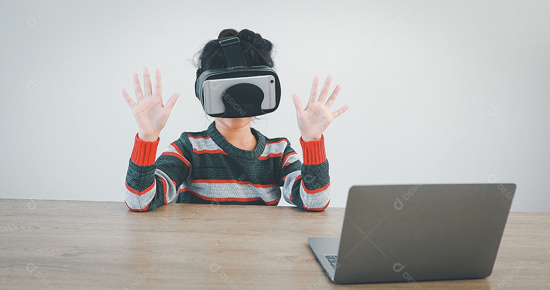 Linda menina criança usando oculos realidade virtual usando notebook