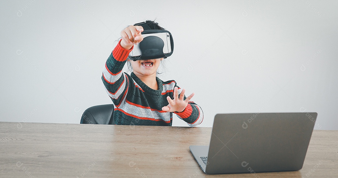 Linda menina criança usando oculos realidade virtual usando notebook