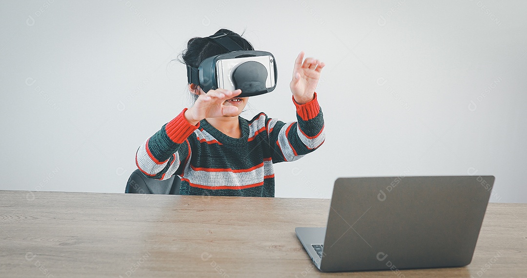 Linda menina criança usando oculos realidade virtual usando notebook
