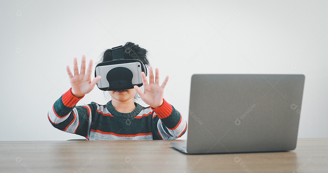 Linda menina criança usando oculos realidade virtual usando notebook