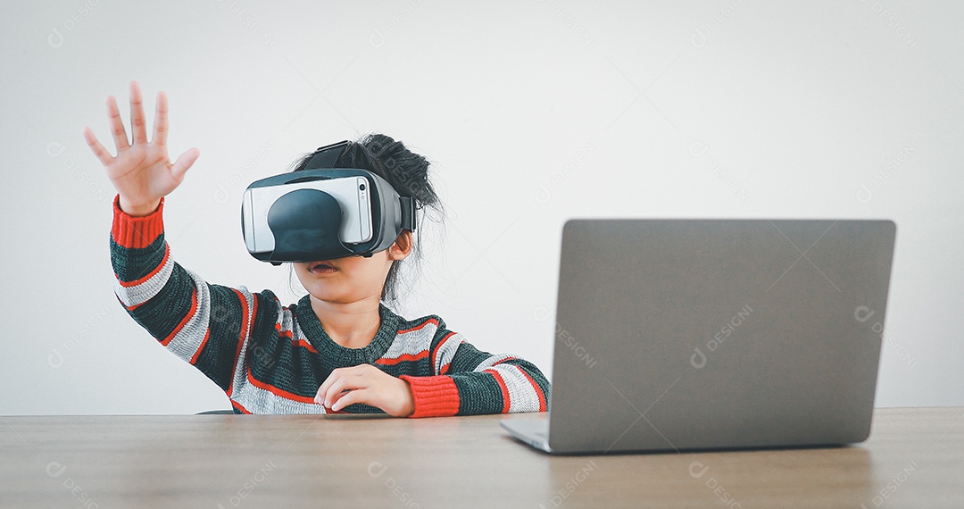 Linda menina criança usando oculos realidade virtual usando notebook