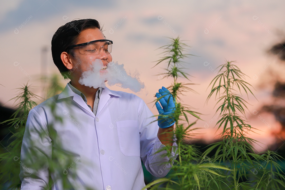 Homem jovem usando jaleco branco fumando droga baseado cannabis