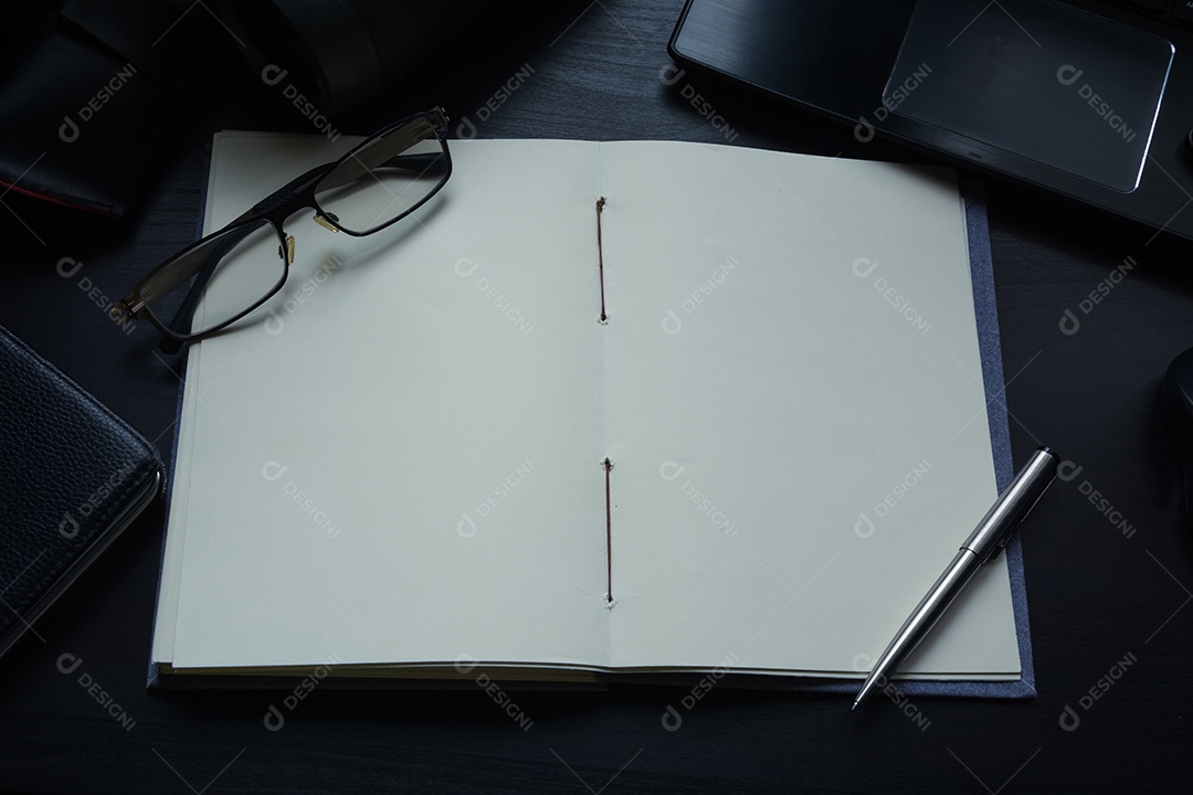 Caderno na mesa, espaço vazio no caderno para inserir texto ou imagem.