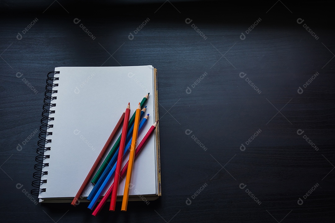 Caderno na mesa, espaço vazio no caderno para inserir texto ou imagem.