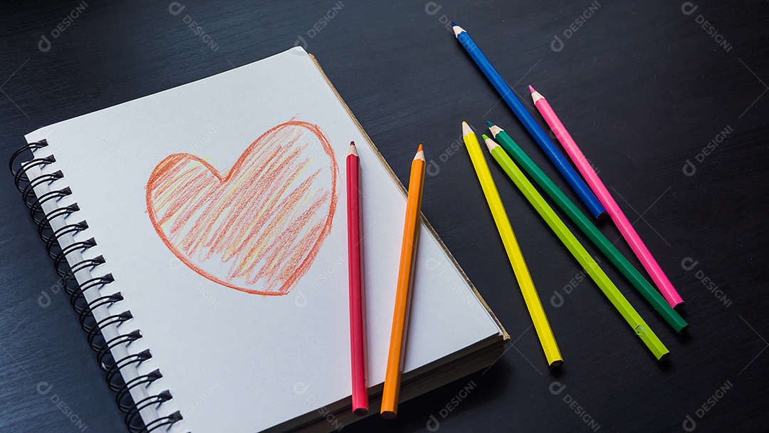 Caderno na mesa, desenho de coração no caderno.
