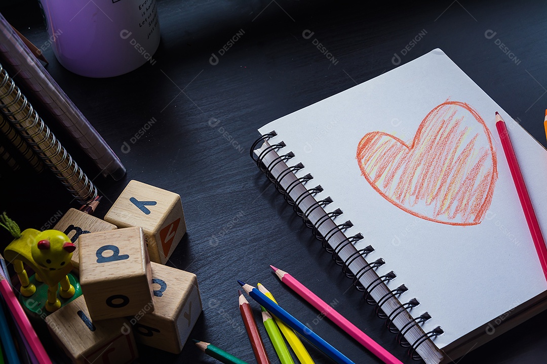 Caderno na mesa, desenho de coração no caderno.