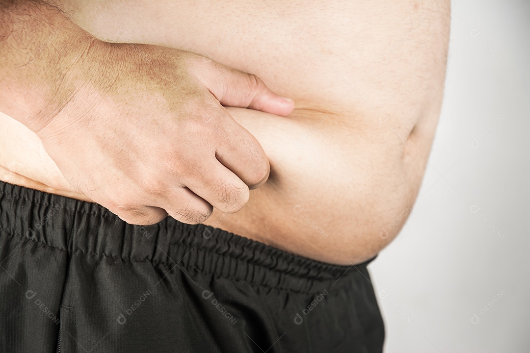 Corpo de homem com excesso de peso com as mãos tocando a gordura da barriga