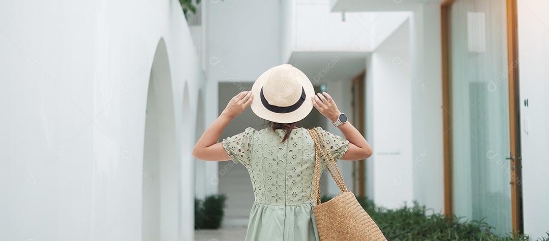 Feliz viajante mulher de vestido branco e chapéu desfruta no feriado.