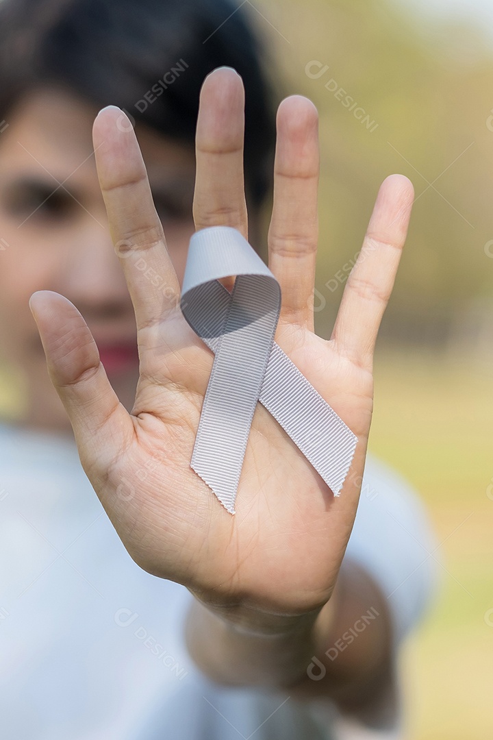 Mês de conscientização do câncer cerebral, mão de mulher segurando a cor cinza.