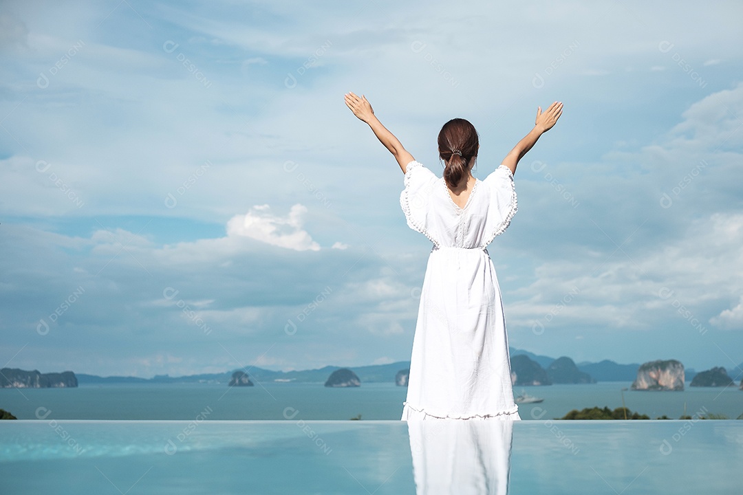 Feliz viajante de vestido branco desfruta de uma bela vista, sozinha