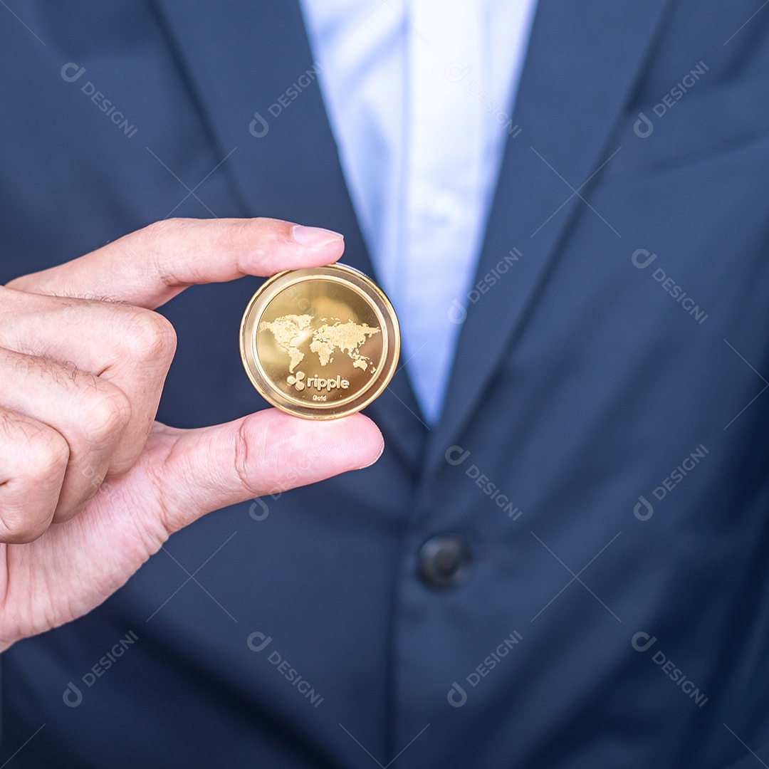 Mão de empresário segurando a moeda de criptomoeda Ripple dourada (XRP)