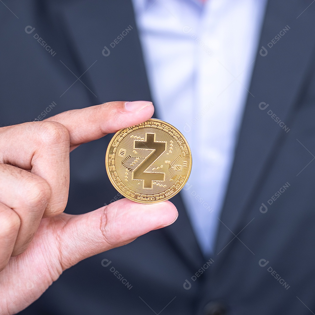Mão de empresário segurando a moeda de criptomoeda dourada ZCASH (ZEC)