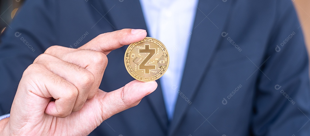 Mão de empresário segurando a moeda de criptomoeda dourada ZCASH (ZEC),