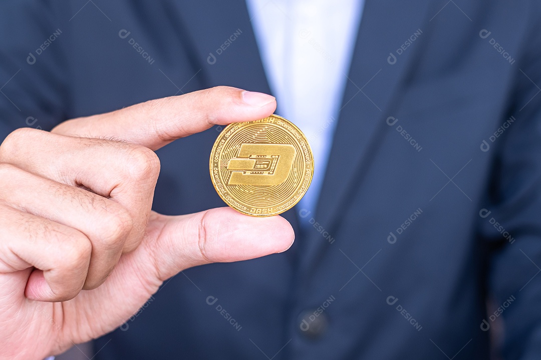 Mão de empresário segurando a moeda de criptomoeda Dash dourada, Crypto