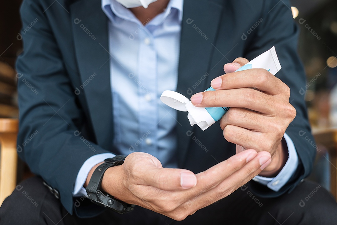 Empresário usando máscara cirúrgica e mãos usando desinfetante lavagem contra Covid 19
