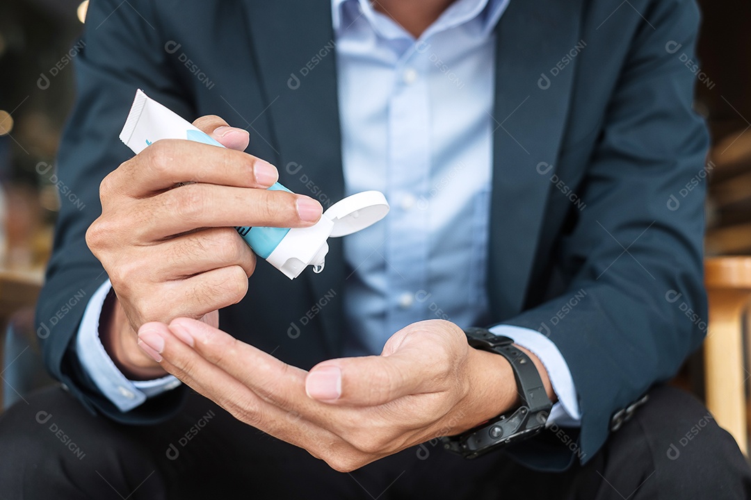 Empresário usando máscara cirúrgica e mãos usando desinfetante lavagem contra Covid 19