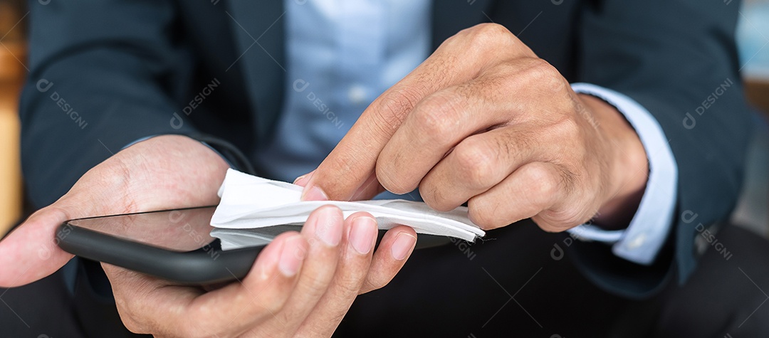 Empresário de terno limpando smartphone por lenços umedecidos