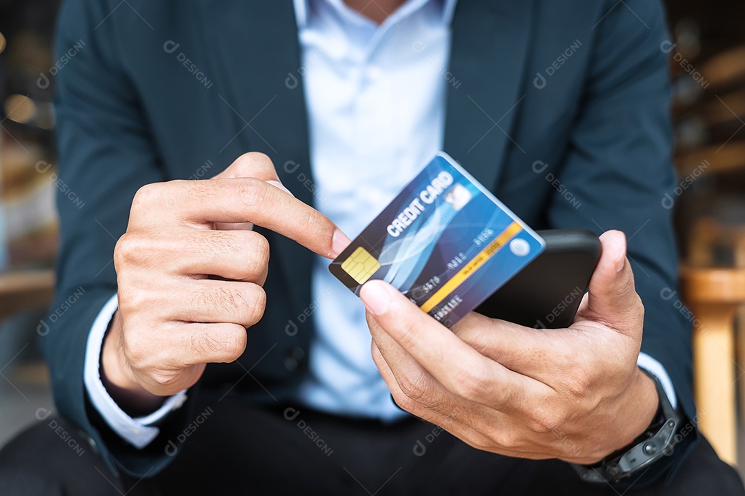 Empresário segurando cartão de crédito e usando smartphone