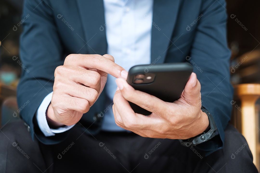 jovem empresário de terno segurando e usando smartphone para sms