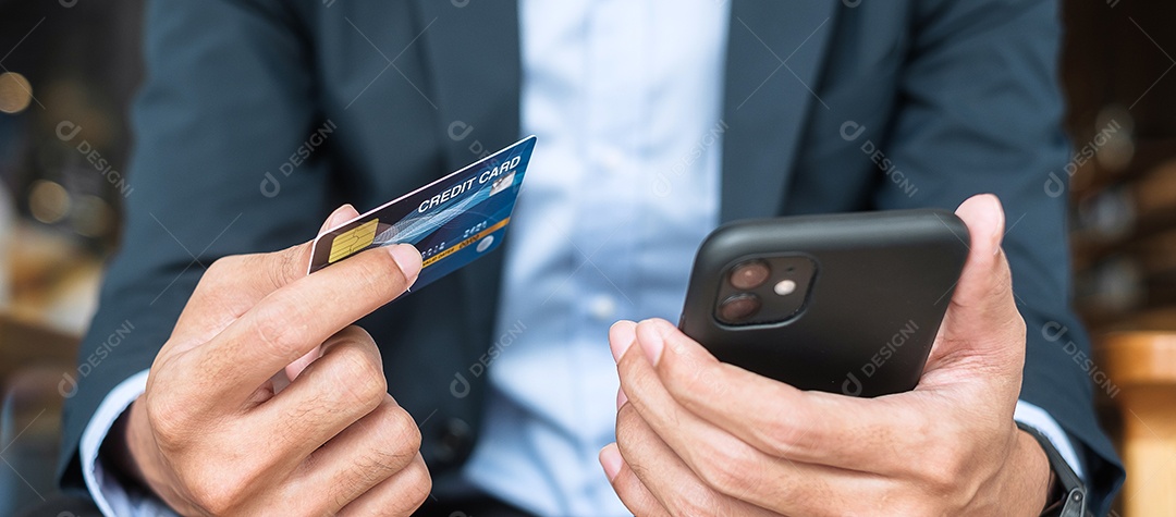 Empresário segurando cartão de crédito e usando smartphone