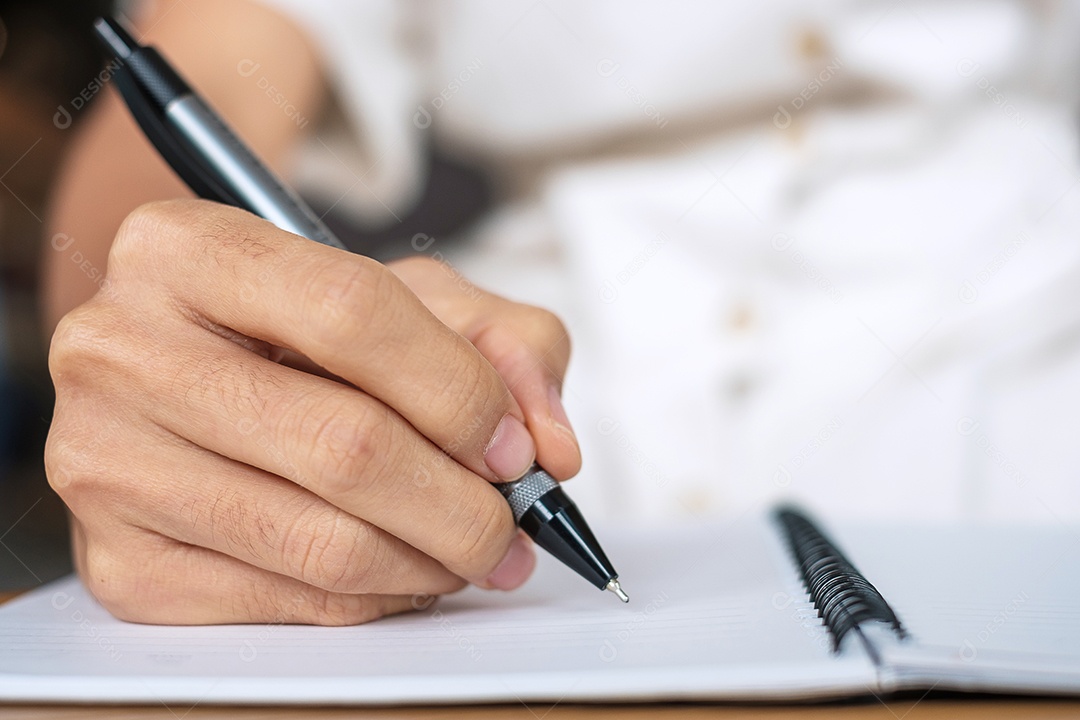 Empresário de terno escrevendo algo no notebook no escritório