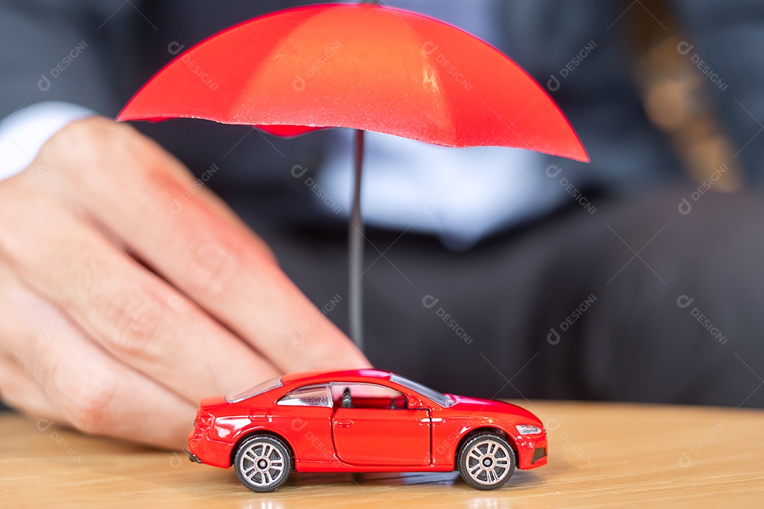 Capa de mão de empresário ou brinquedo de carro vermelho de proteção na mesa.