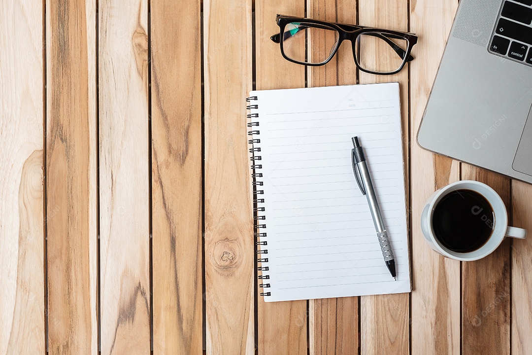 Vista superior Mesa de escritório com caneta, computador portátil, caderno em branco