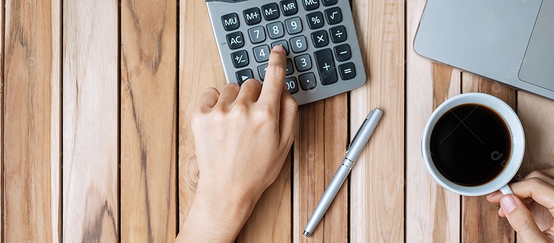 Vista superior Mão de mulher de negócios segurando a xícara de café e calculando