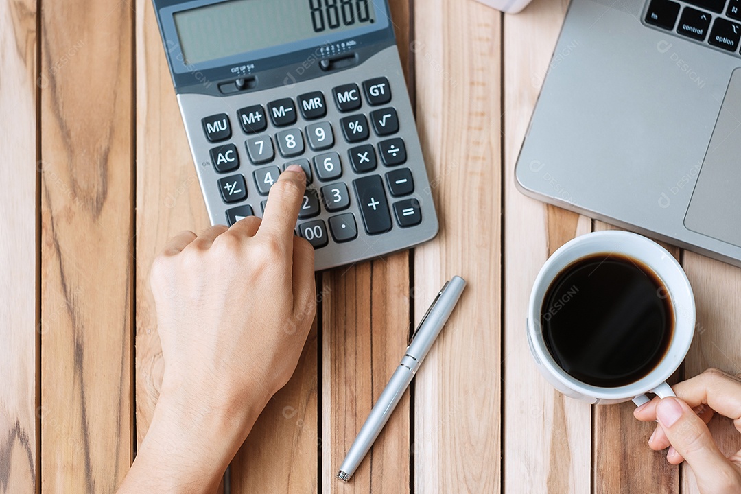 Vista superior Mão de mulher de negócios segurando a xícara de café e calculando