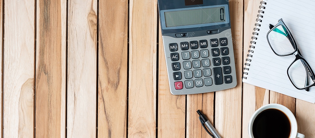 Mesa de escritório vista superior com calculadora, caneta, caderno em branco