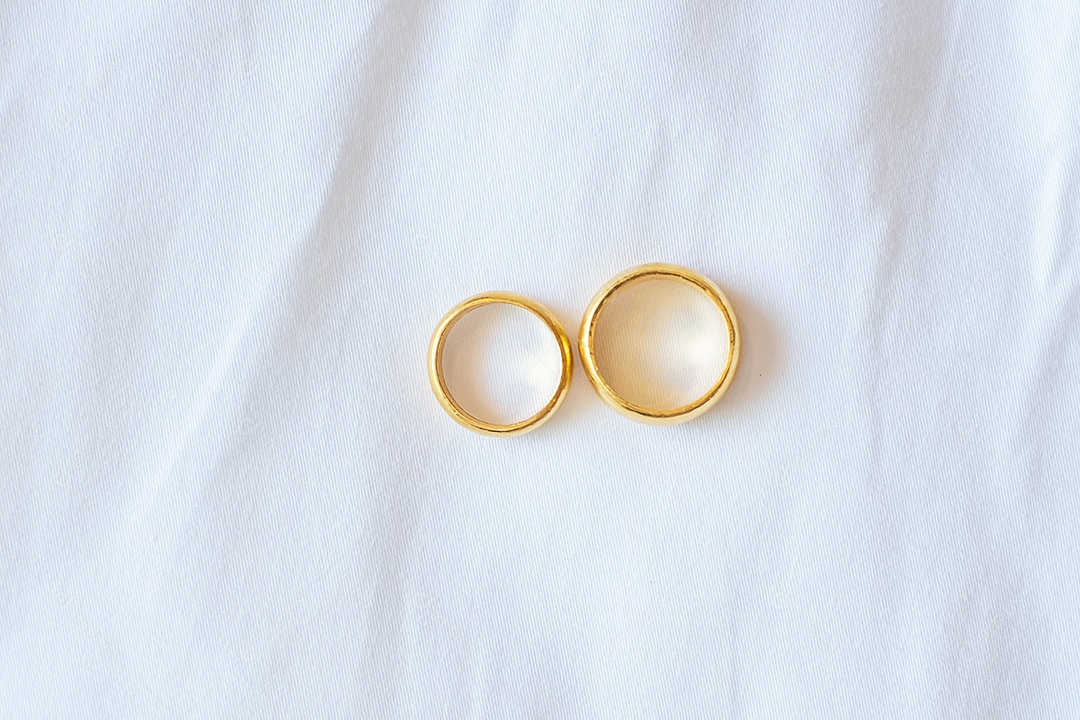 casal anel de noivado dourado sobre fundo branco. Amor, juntos